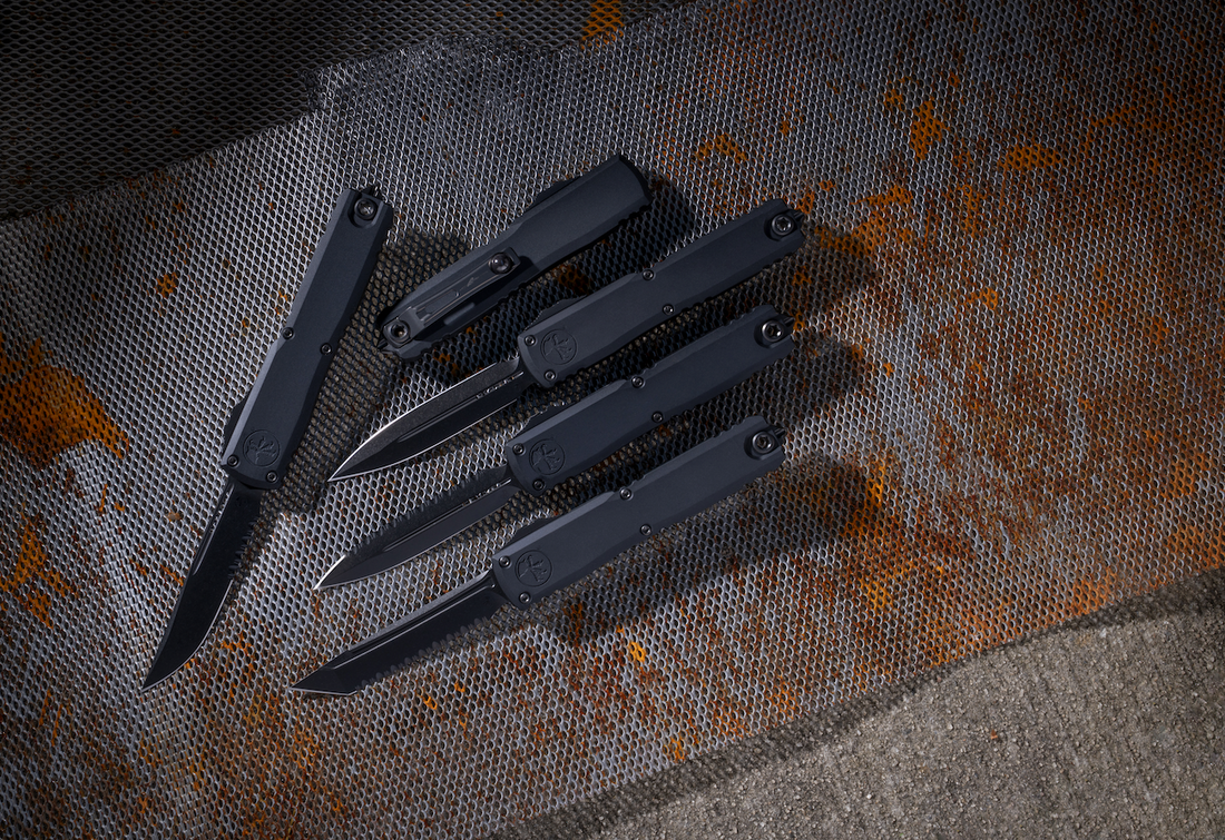 Black tactical folding knives on a rusty metal mesh background