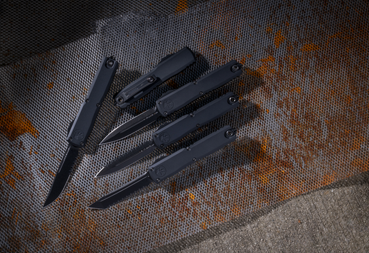 Black tactical folding knives on a rusty metal mesh background