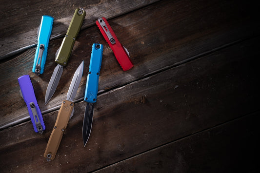 Colorful Ultratech Gen 4 folding knives on rustic wooden surface