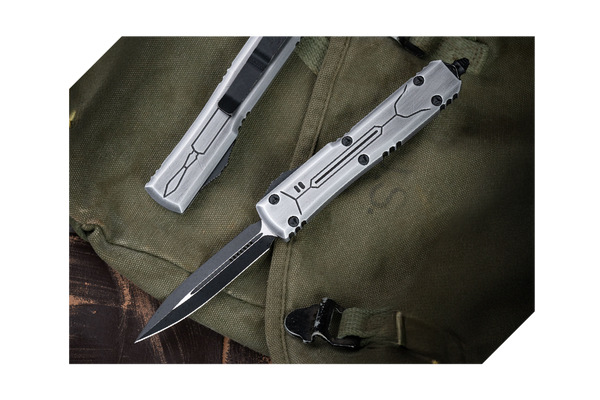 Silver out-the-front automatic knives with textured handles on olive green fabric