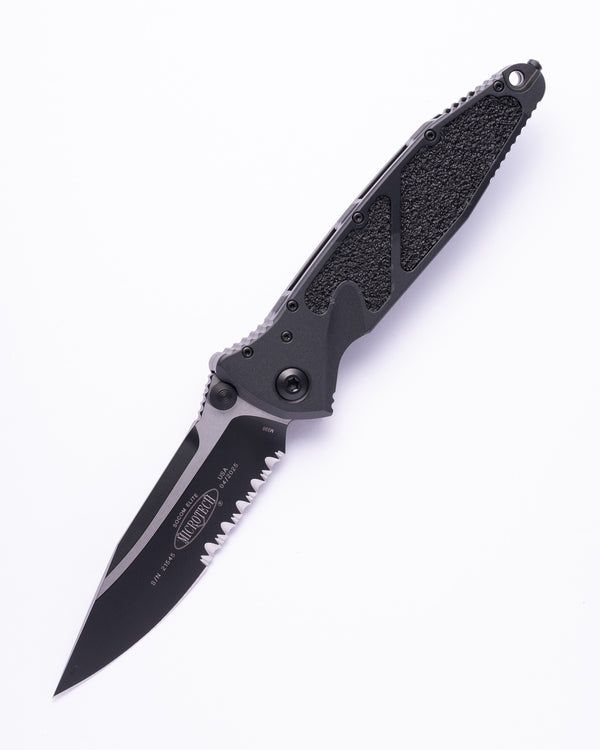 Black folding tactical knife with serrated blade and textured handle on white background