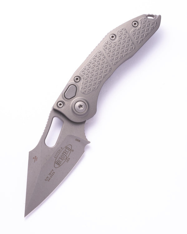 Automatic folding knife with triangle textured aluminum gray handle on a white background.