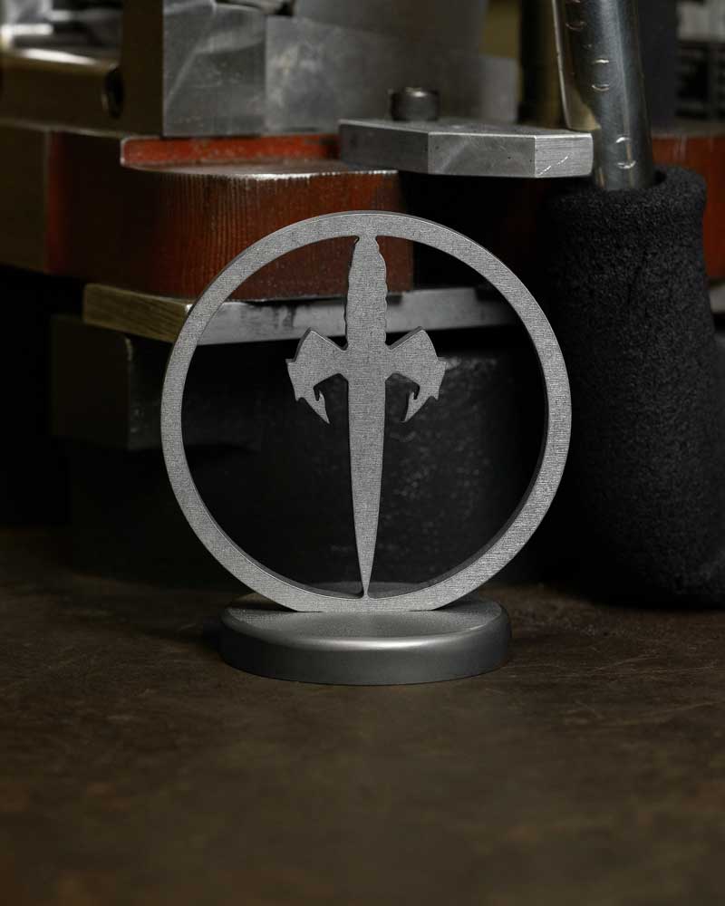 Metal desk stand with sword emblem, industrial background, minimalist design